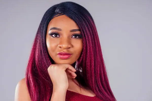 Una giovane donna con capelli color prugna, un look audace che le sta benissimo.