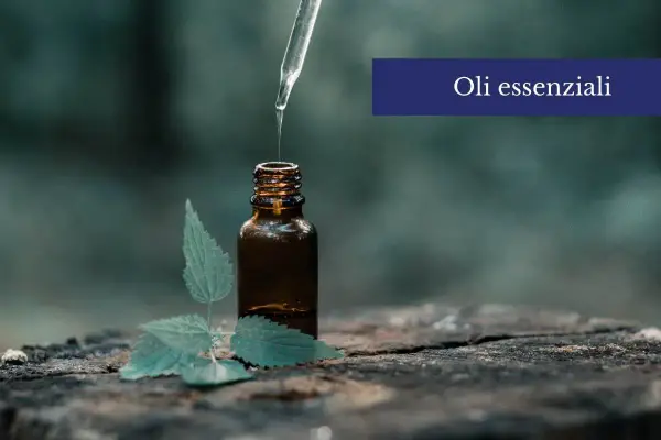 Una goccia di olio essenziale cade da un contagocce in una bottiglia ambrata, accanto a una foglia verde. Scopri come usare gli oli essenziali sulla pelle per un benessere naturale.